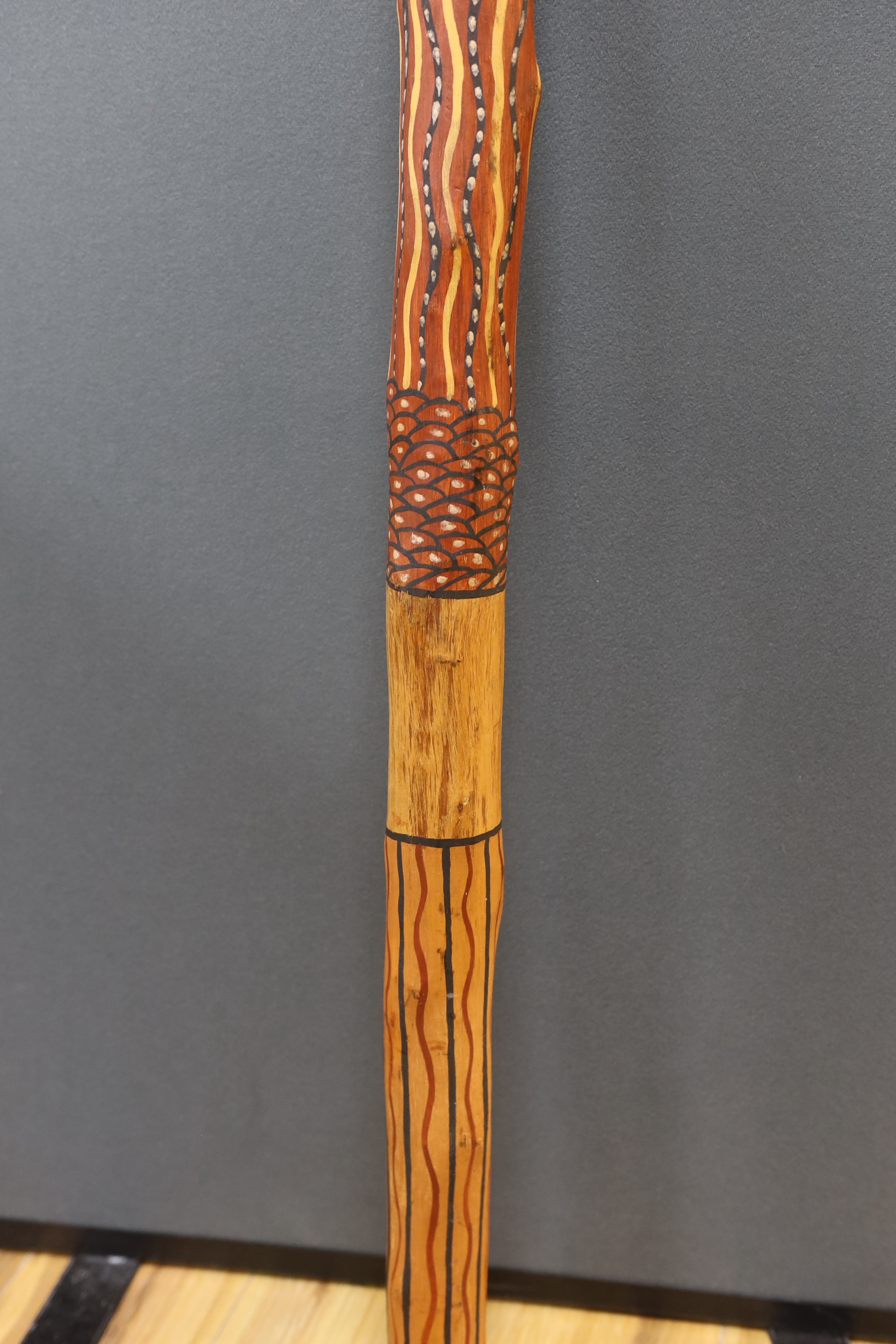 An Aboriginal decorated didgeridoo, Walpari tribe oil on canvas, a fabric painted panel and two decorated wooden sticks, canvas 50x61cm